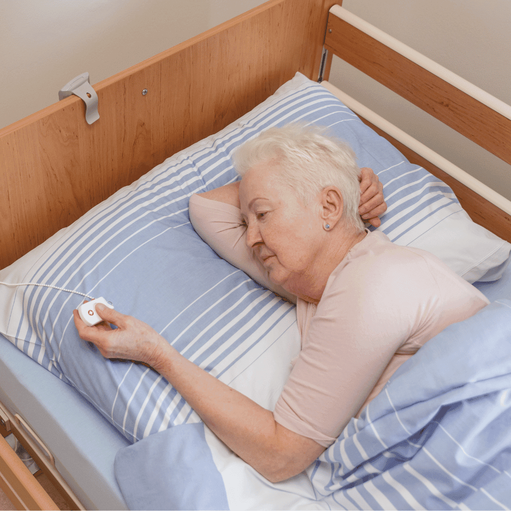 Tísňové tlačítko u postele na řetízku pro klienta domova seniorů