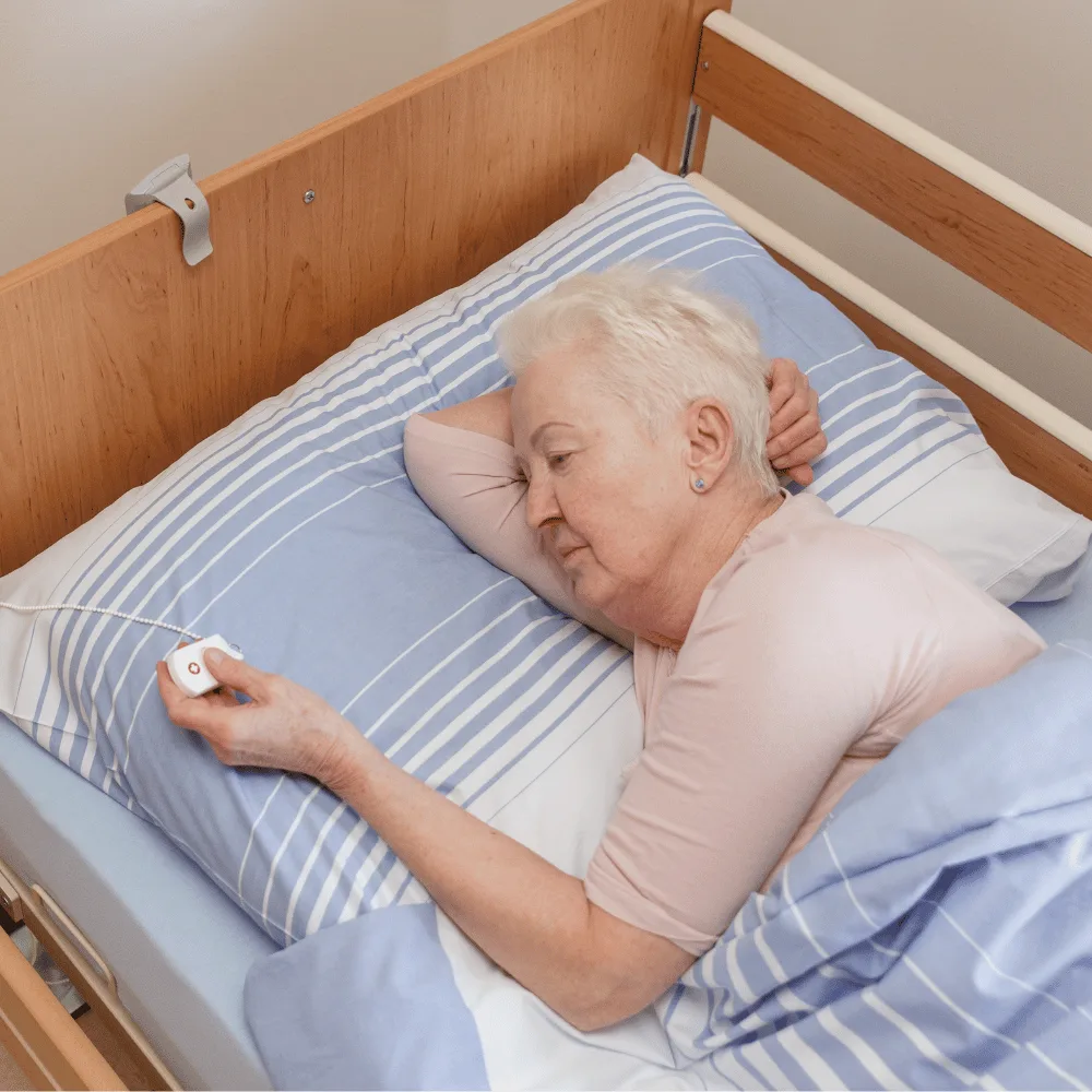 Tísňové tlačítko u postele na řetízku pro klienta domova seniorů